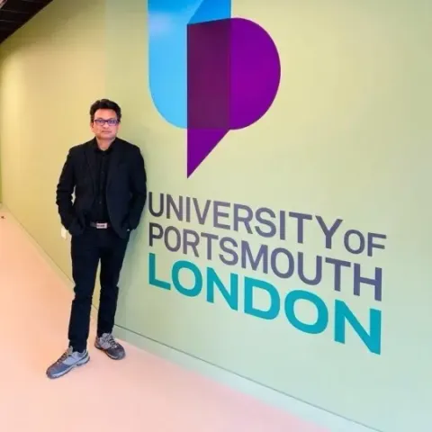academic in front of UoP London sign