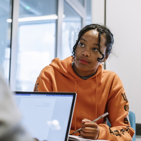 girl looking at someone with laptop