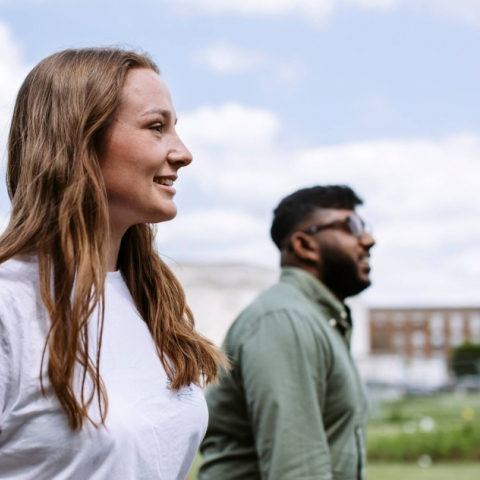 young woman standing next to young man looking into the horizon 