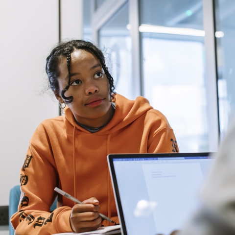 girl looking at someone with laptop