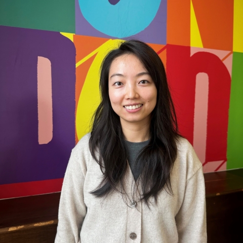 An image of Wenqing Chen standing against the University of Portsmouth London background