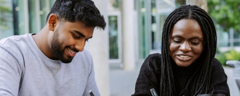 Two students working together from the same book in Eldon seating area