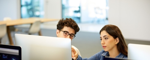 girl pointing at computer screen, boy looking