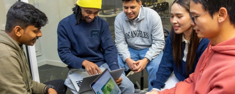 students around laptop